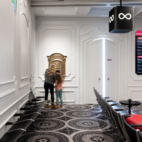 Photograph of two people looking inside the door of the sculpture.