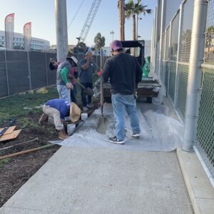 Sign installation team taking cement from dozer. Photo by staff