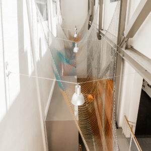 installation situated in the atrium tinted stainless steel and brass ball chain suspended from the beams supporting the skylights