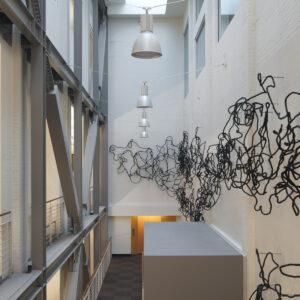 India ink-soaked and twisted cotton cord sculpted to arc and loop in sequences of extended lengths that traverse the walls of the Atrium