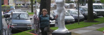 <h3>2010, MJ Anderson standing with her sculpture The Scales of Justice for the Justice Building</h3>