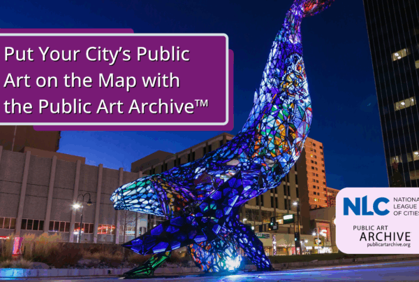 A large colorful whale sculpture placed outside with building in the back and the NLC and PAA logo placed on top.
